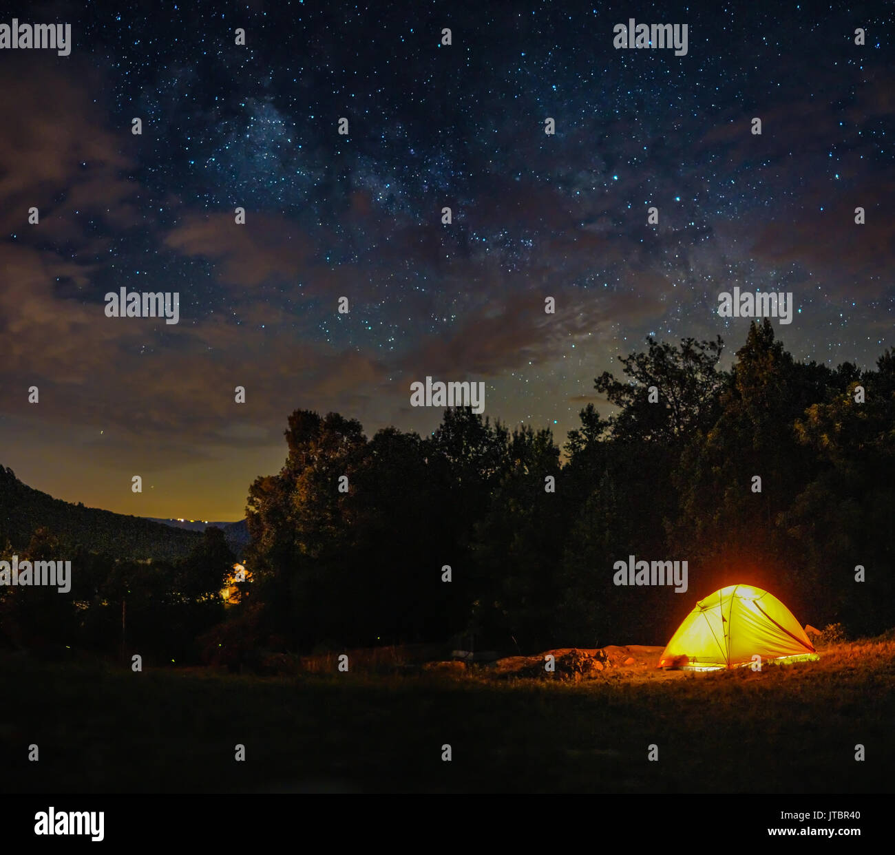 A camping tent under milky way sky and twilight at night Stock Photo