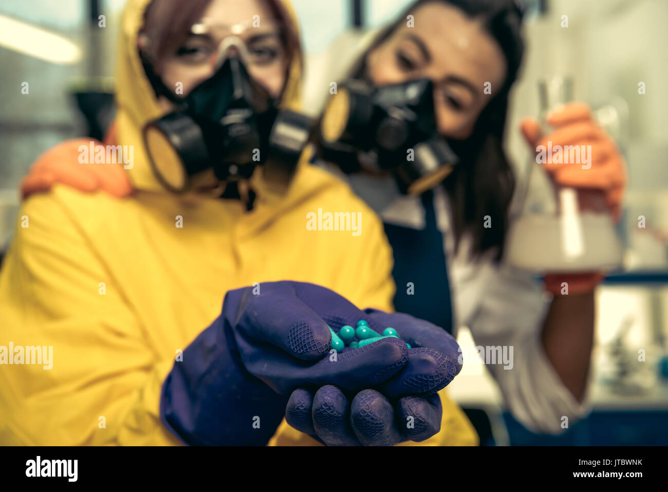 two young women chemists working at scientific laboratory with drugs