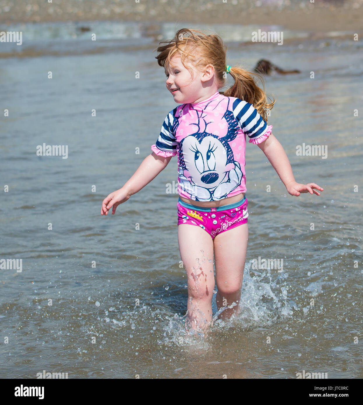 Little girl playing on the beach Stock Photo