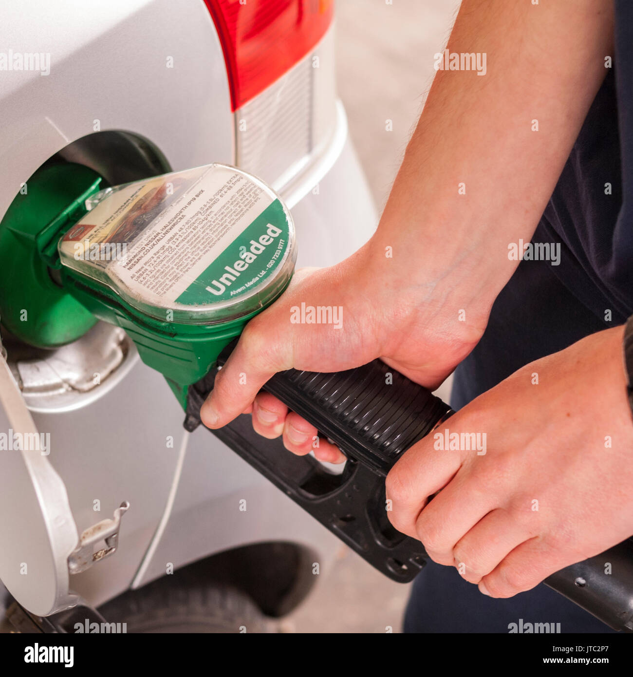 A man filling his car up with unleaded petrol in the Uk Stock Photo