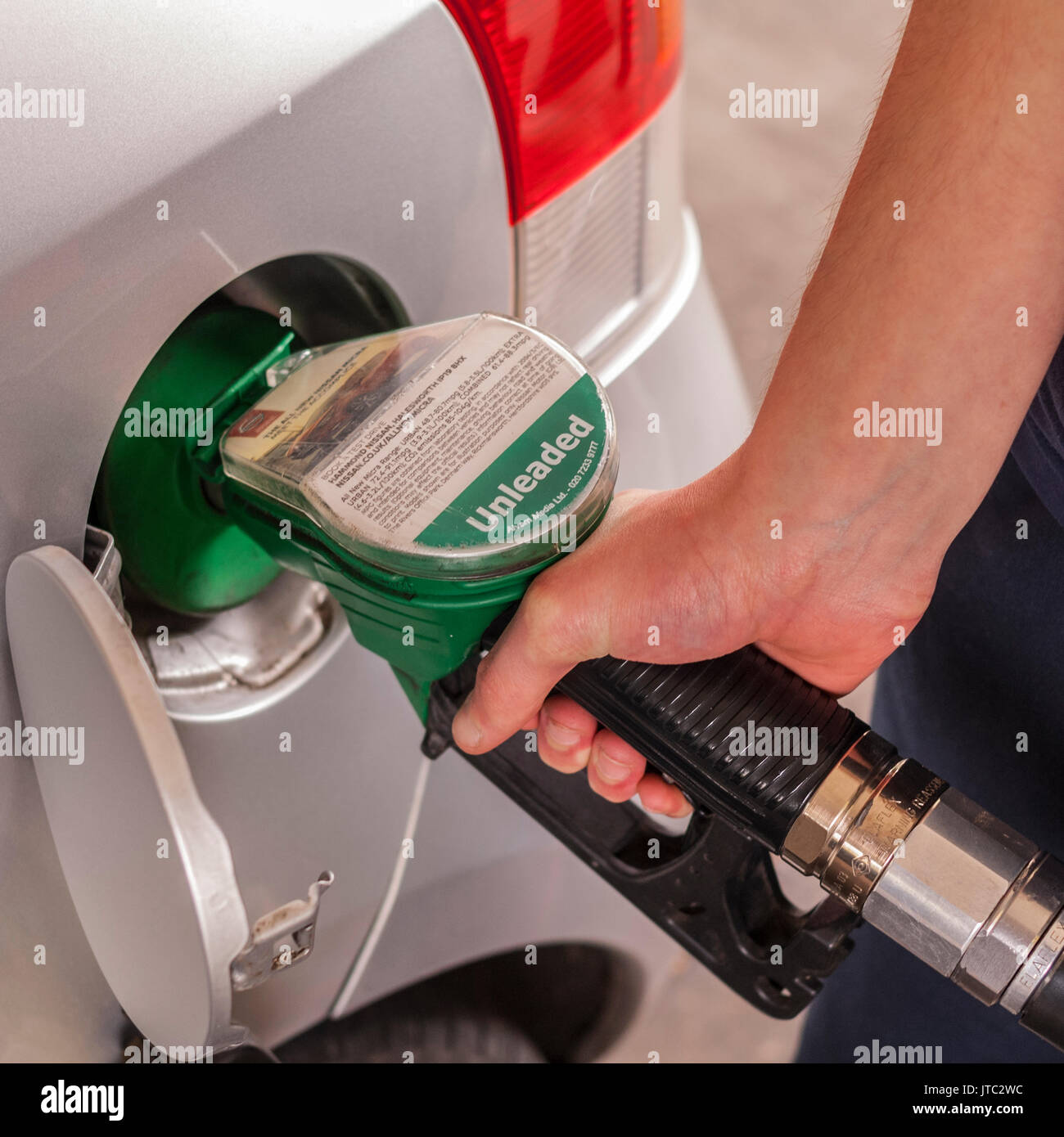 A man filling his car up with unleaded petrol in the Uk Stock Photo