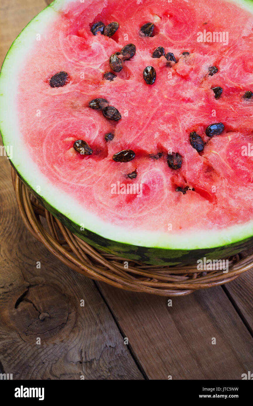 Cut in half watermelon on old wooden table. Red ripe fruit on wood background with copy space top view image Stock Photo