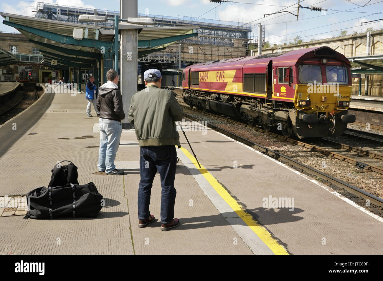 Rail enthusiasts at Carlisle station photographing EWS class 66 diesel locomotive 66069 Stock Photo