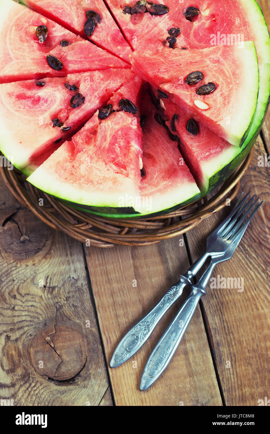 Cut in half watermelon on old wooden table. Red ripe fruit on wood background with copy space top view image Stock Photo