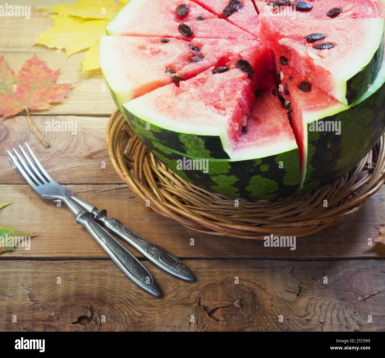 Cut in half watermelon on old wooden table. Red ripe fruit on wood background with copy space top view image Stock Photo