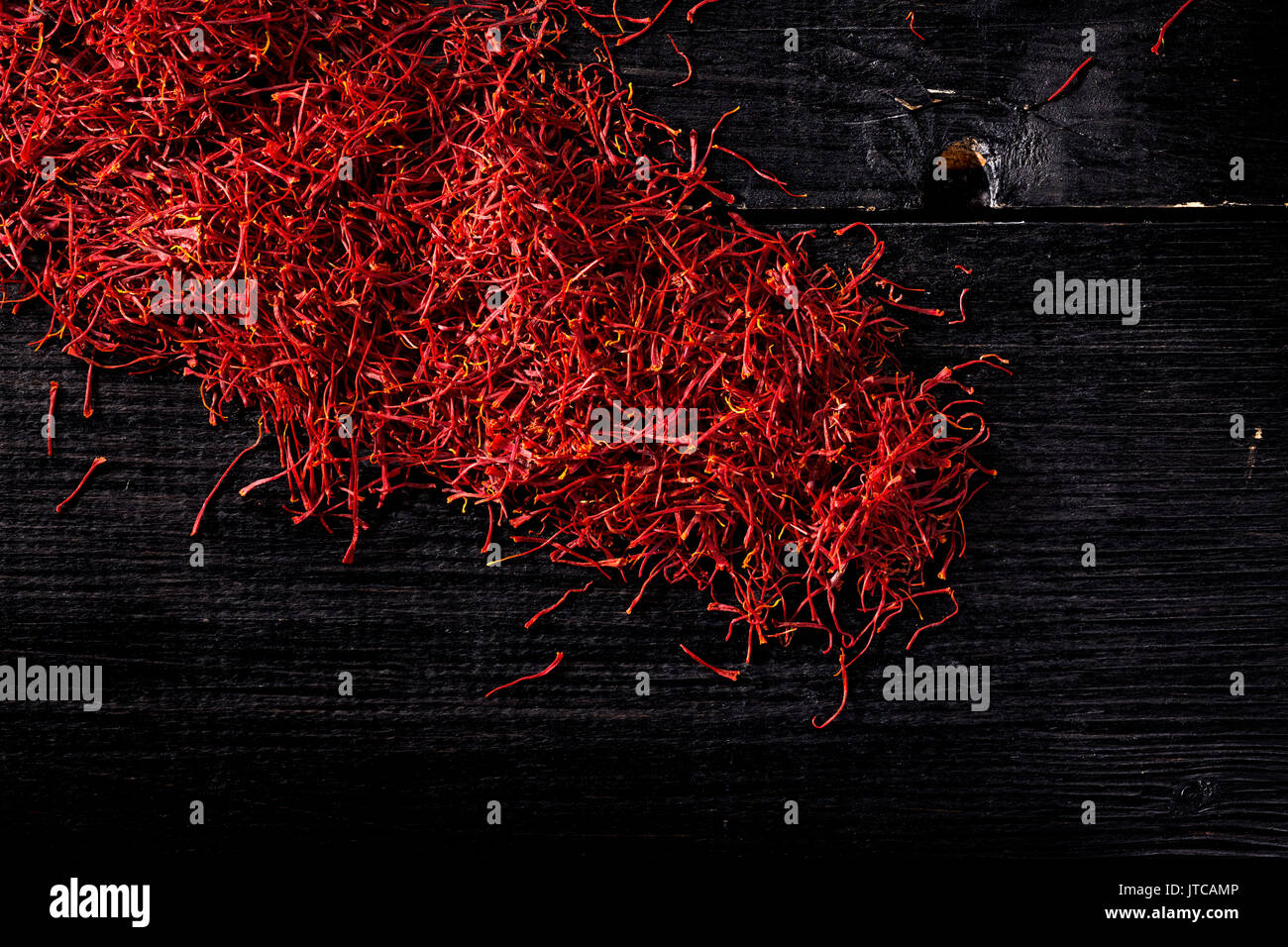 saffron crocus threads on black wooden board, view from above