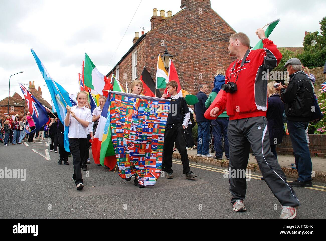 People parade through the streets at an Olympic torch relay event at ...