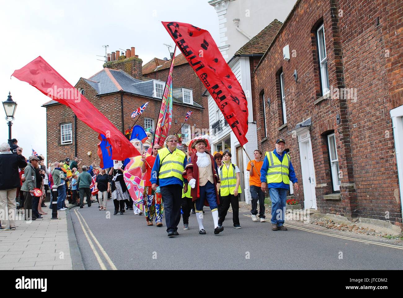 People parade through the streets at an Olympic torch relay event at Rye in East Sussex, England on July 18, 2012. Stock Photo