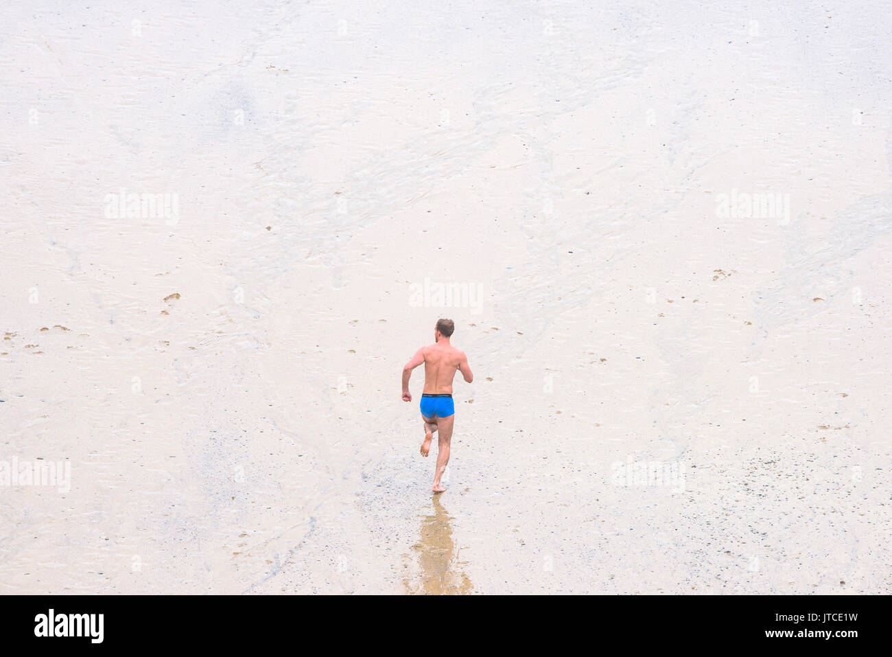 A man running on a beach in his blue Calvin Klein underpants Stock Photo -  Alamy
