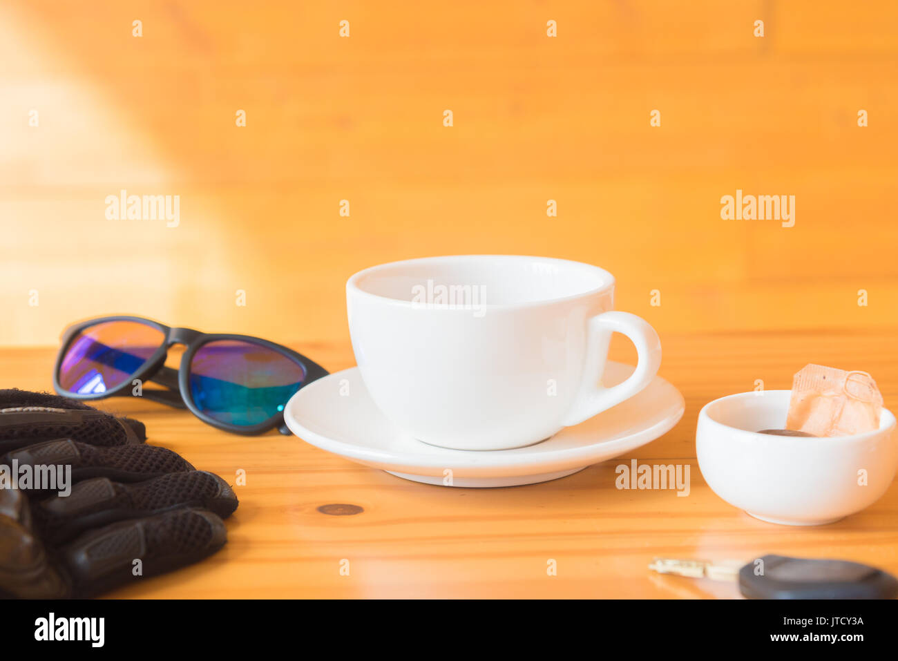 driving glove and glasses place near tea cup on the wooden table Stock Photo