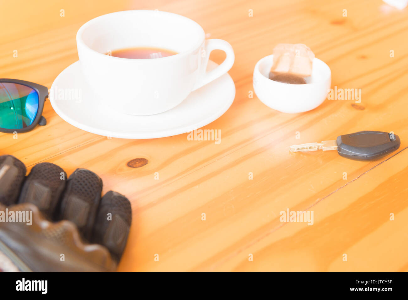 driving glove and glasses place near tea cup on the wooden table Stock Photo