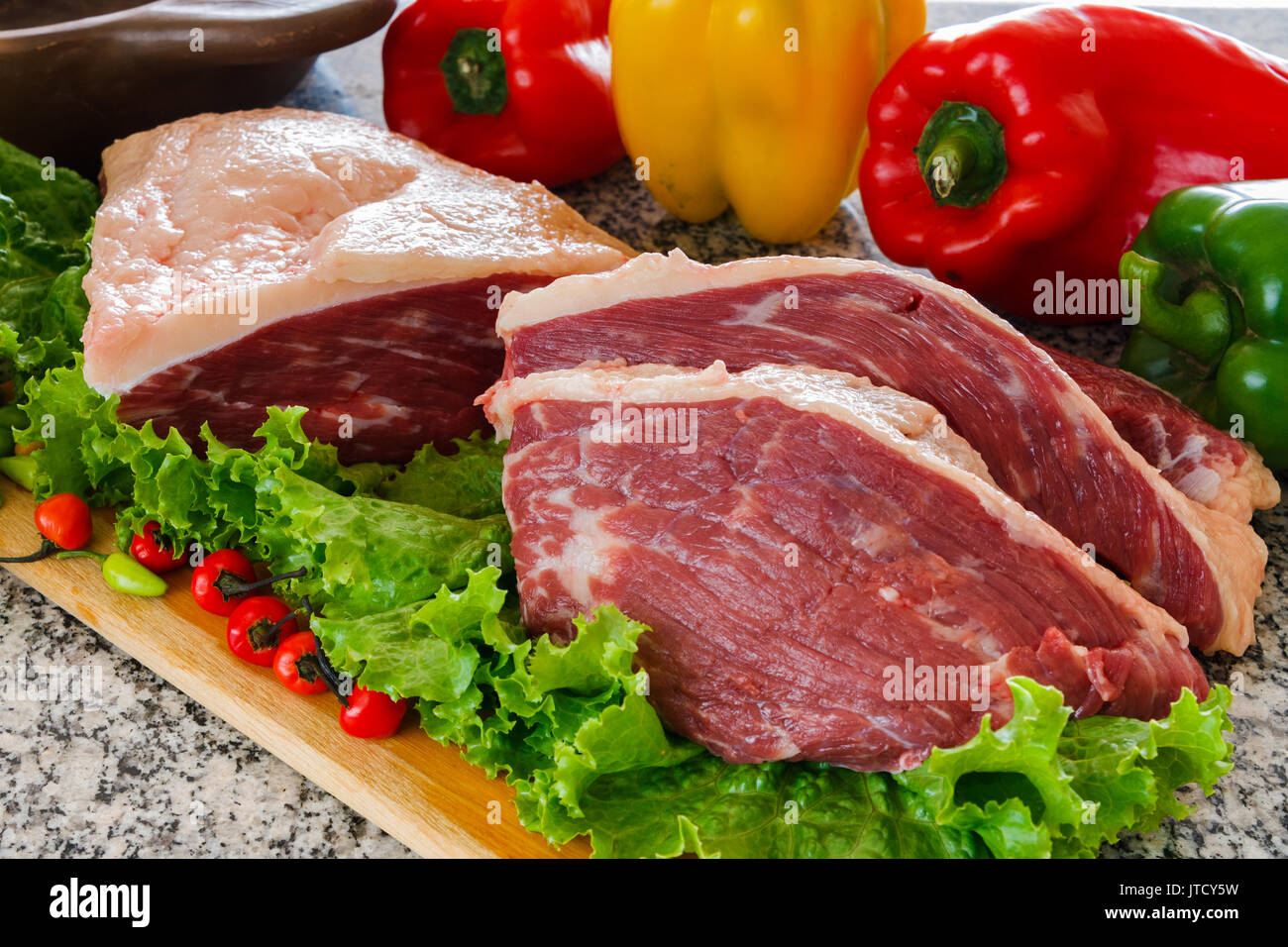Raw fresh meat Picanha steak, traditional Brazilian cut with rosemary,  garlic, knife and black pepper on wooden board. Sliced meat steaks. Copy  space. Top view Stock Photo - Alamy