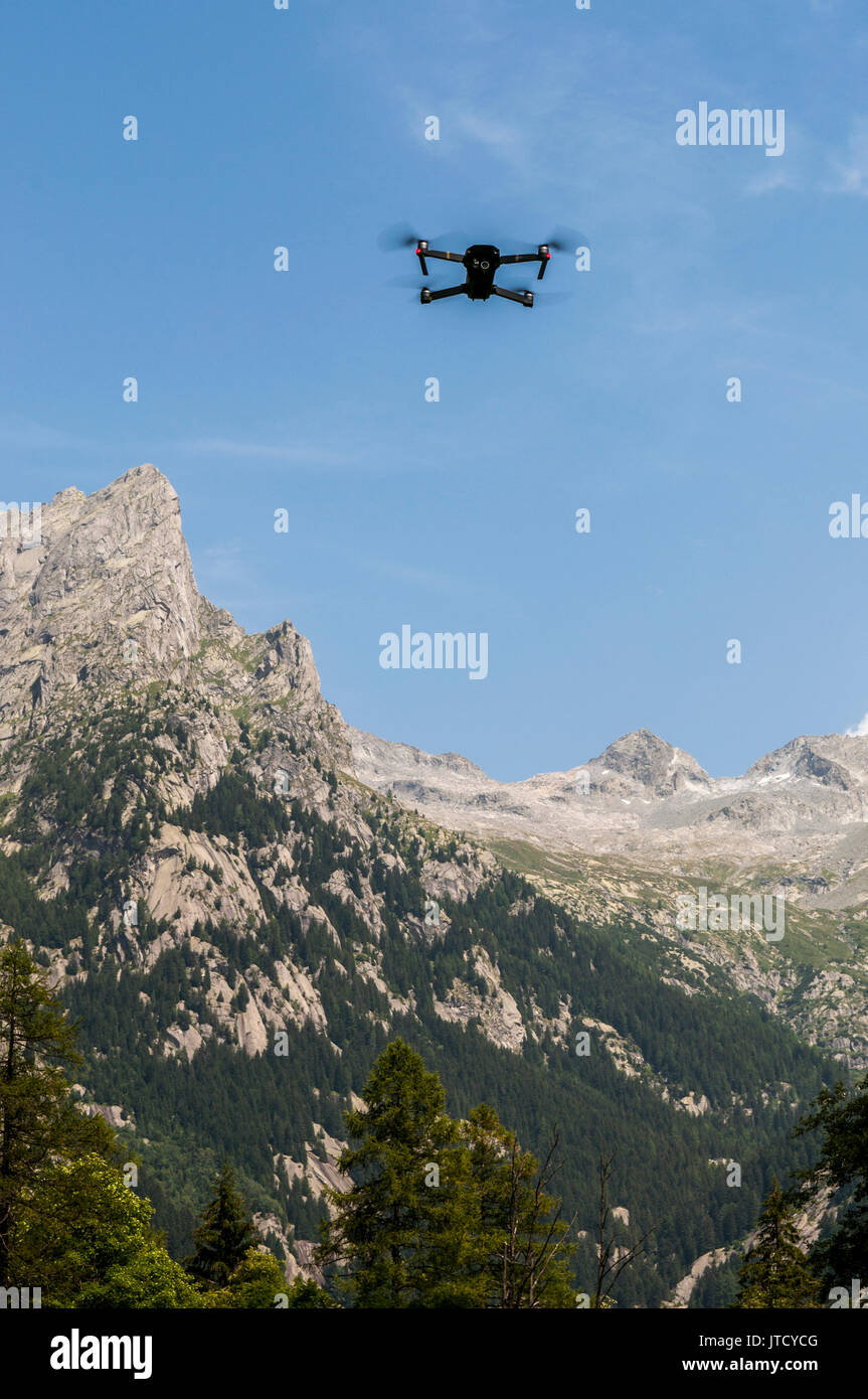A flying drone in the Val di Mello, green valley surrounded by granite