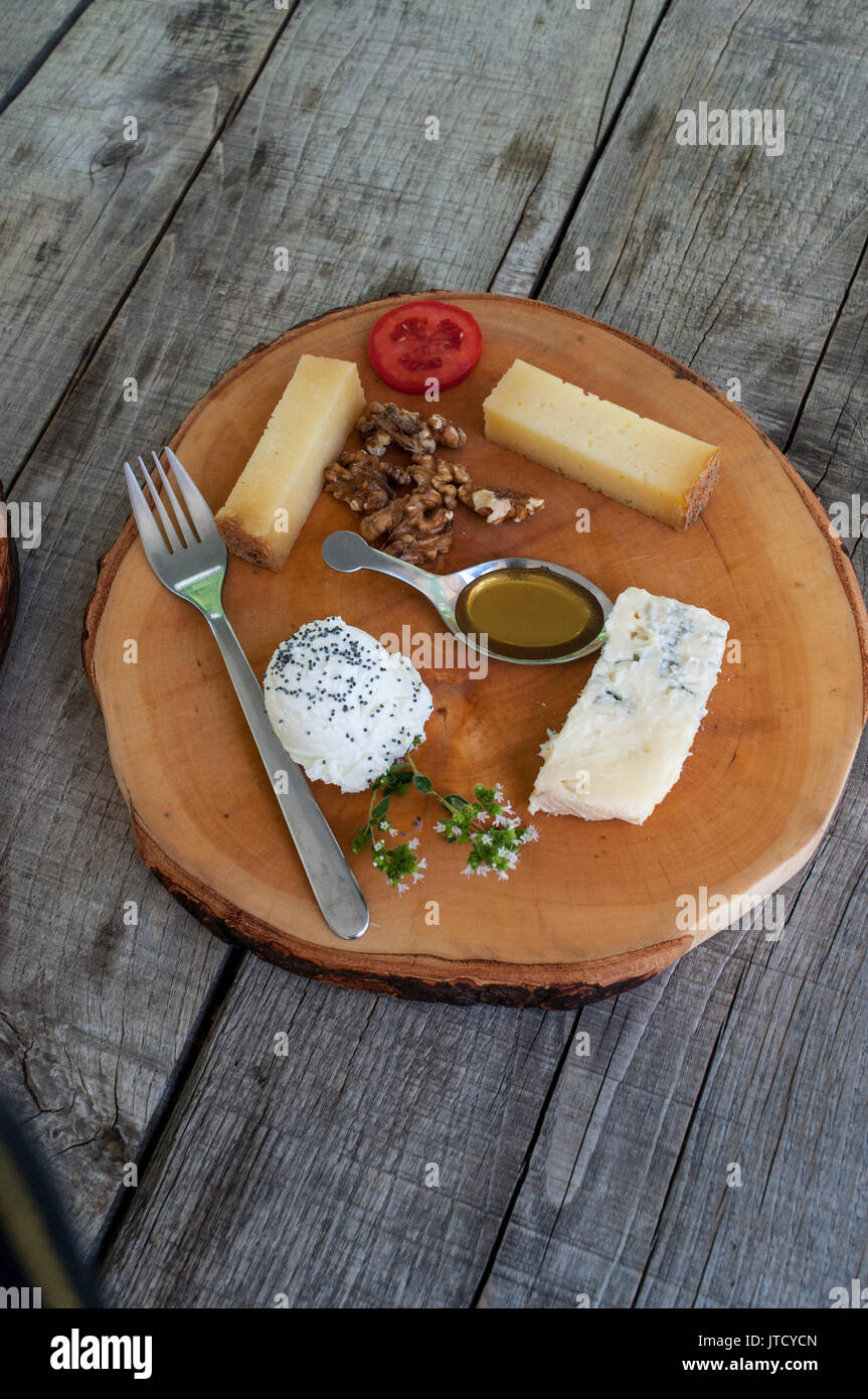 Italy, food and outdoor life: a cheese wooden plate on a wooden table Stock Photo