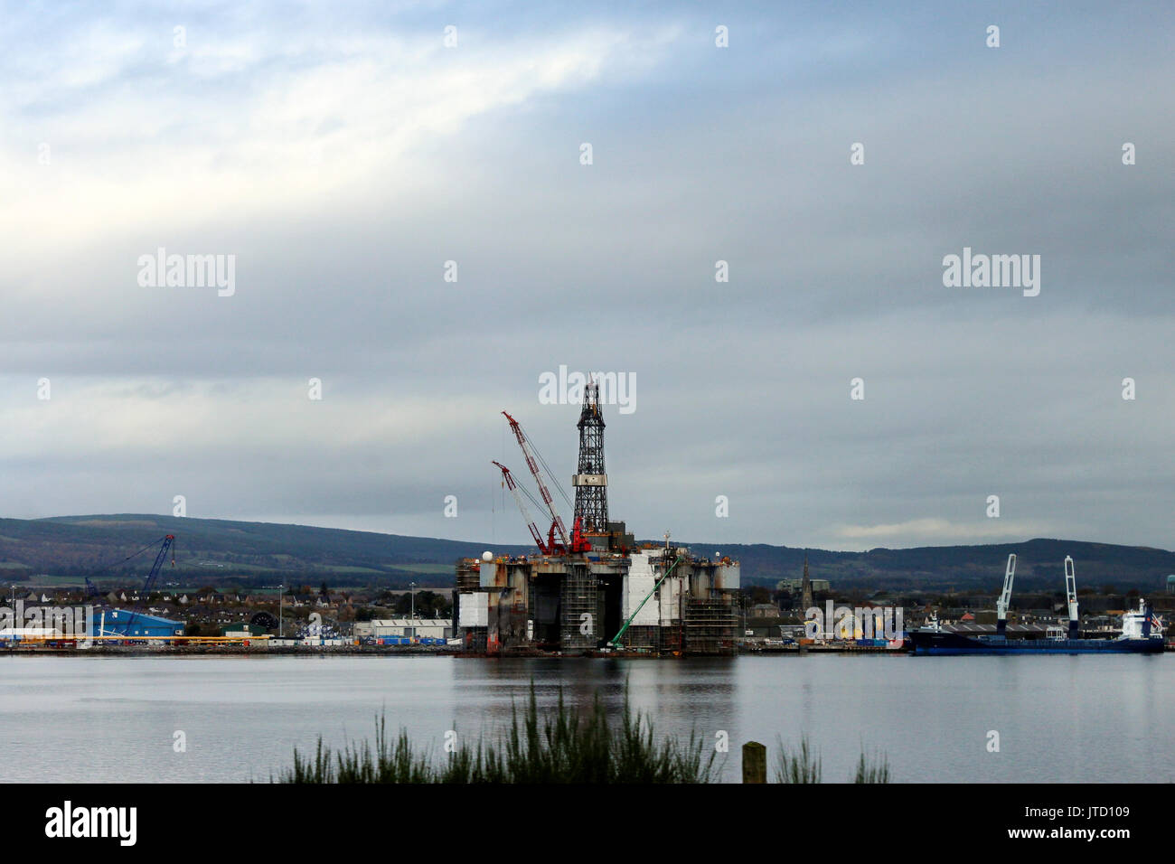 Scotland, Highlands, Scottish Scenery, Oil Platform, Oil Rig, Drill Rig, Industry at Sea, Water Reflections, Green Mountain Background Stock Photo