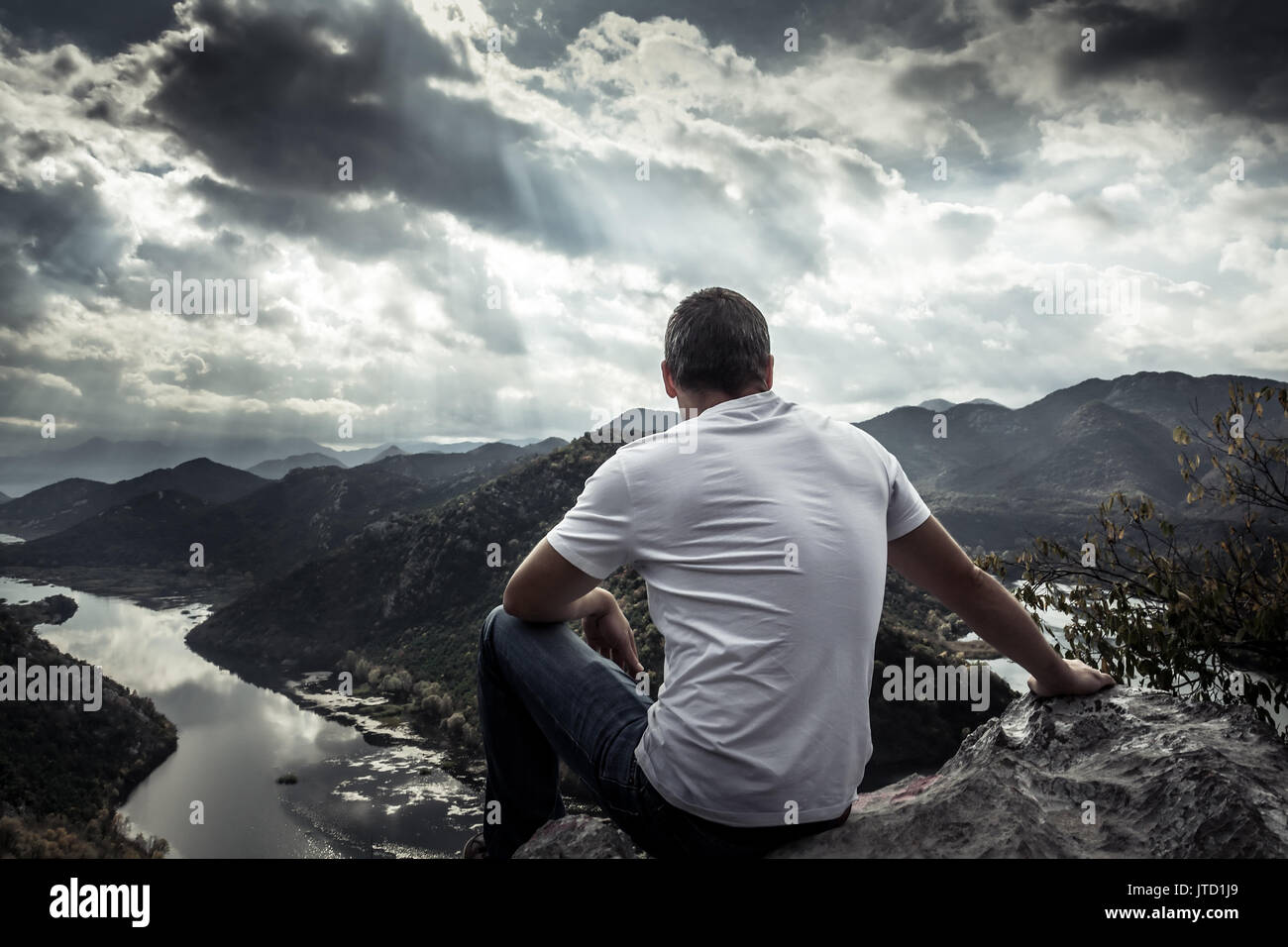 Lonely Man Looking With Hope At Horizon On Mountain Peak With Dramatic