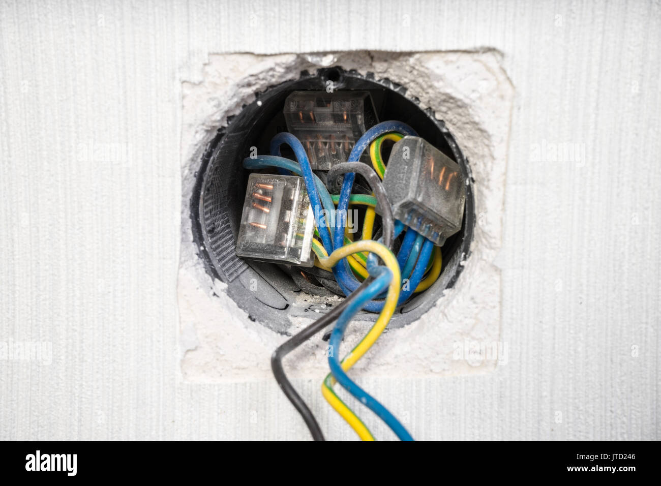 Electrician a wall socket with electronic multimeter Stock Photo