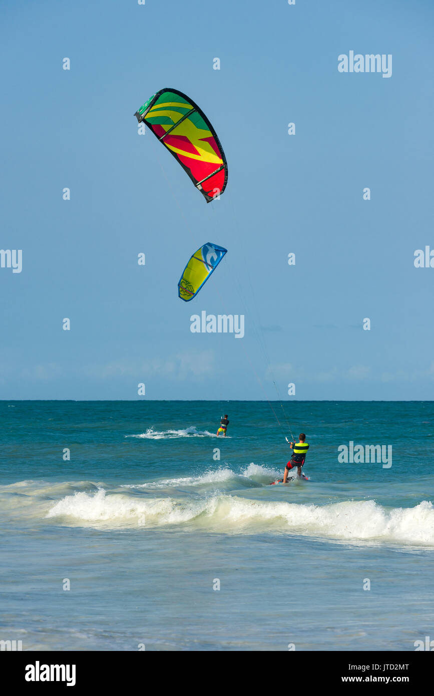 Kite surfer surfing close to shore on board in late afternoon light, Diani, Kenya Stock Photo