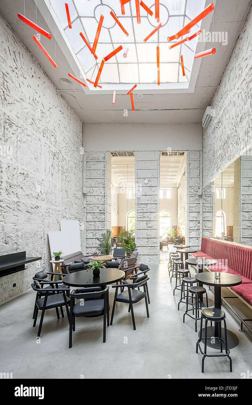 Restaurant With Light Textured Walls And A Large Window On The