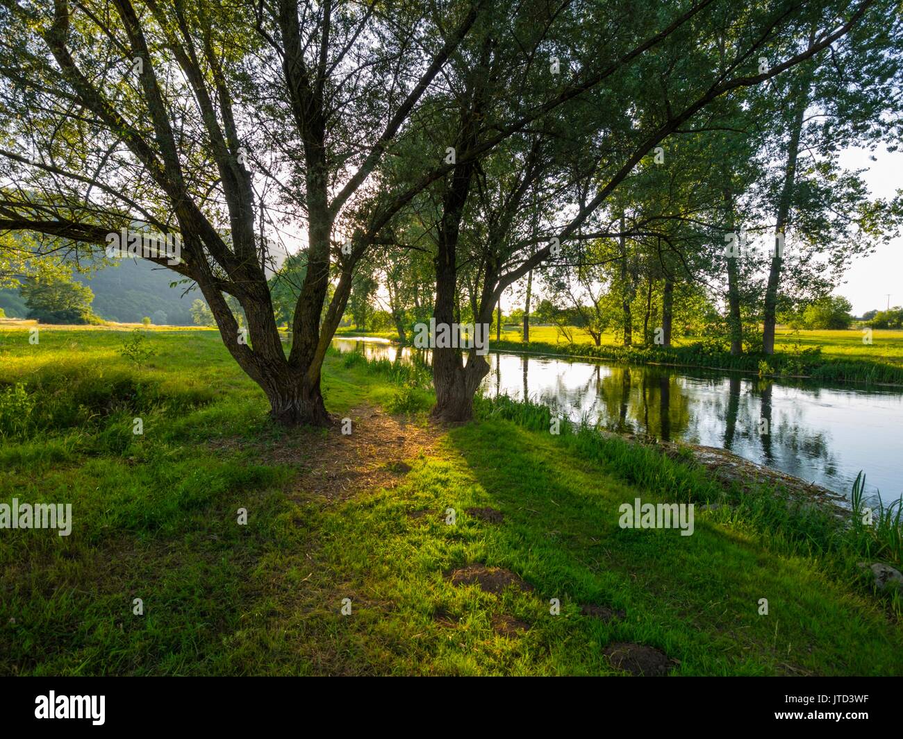 River Gacka Croatia sunset low light shadows pass through tree branches leaves Stock Photo