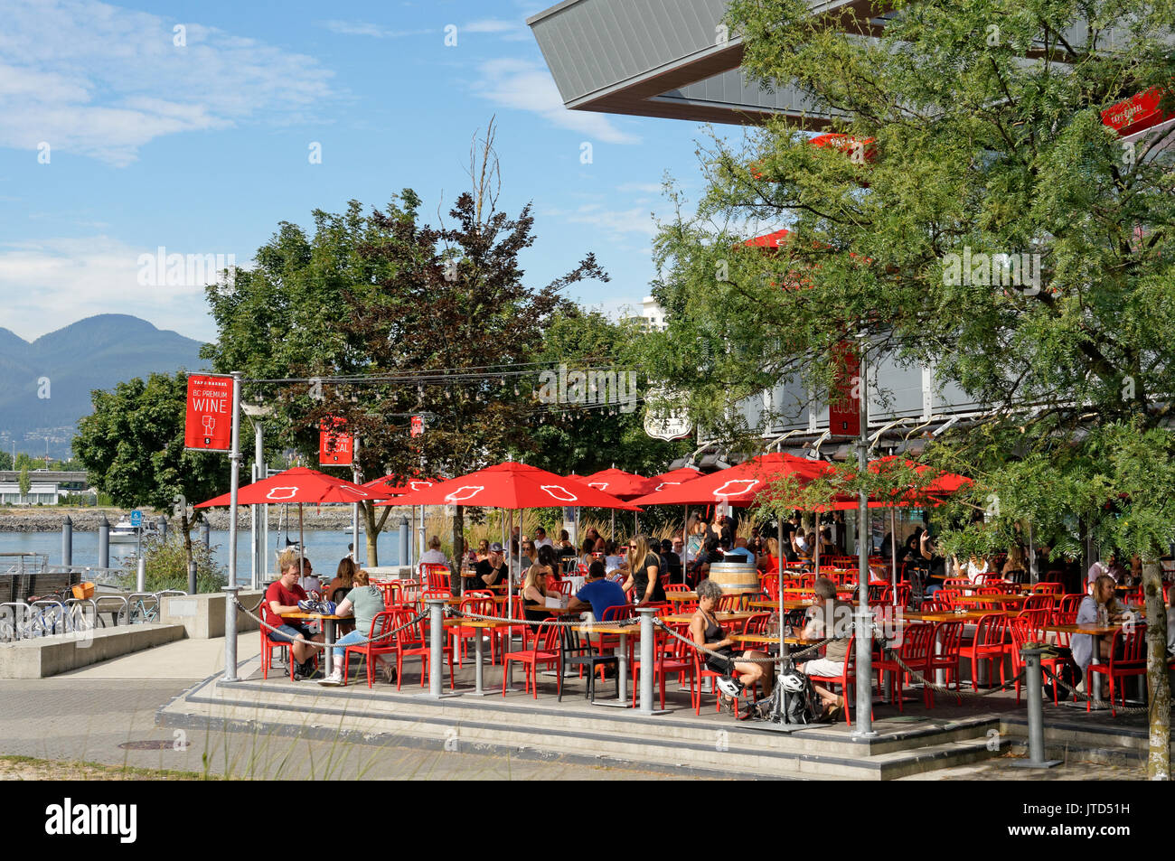 People sitting on the waterfront outdoor patio of Tap and Barrel