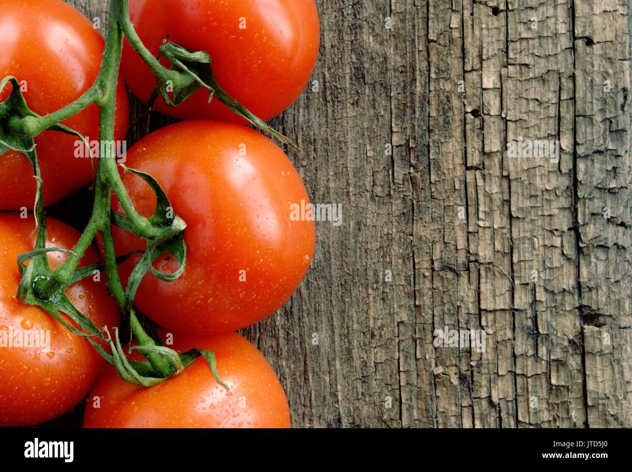 Red tomatoes on the old board Stock Photo - Alamy