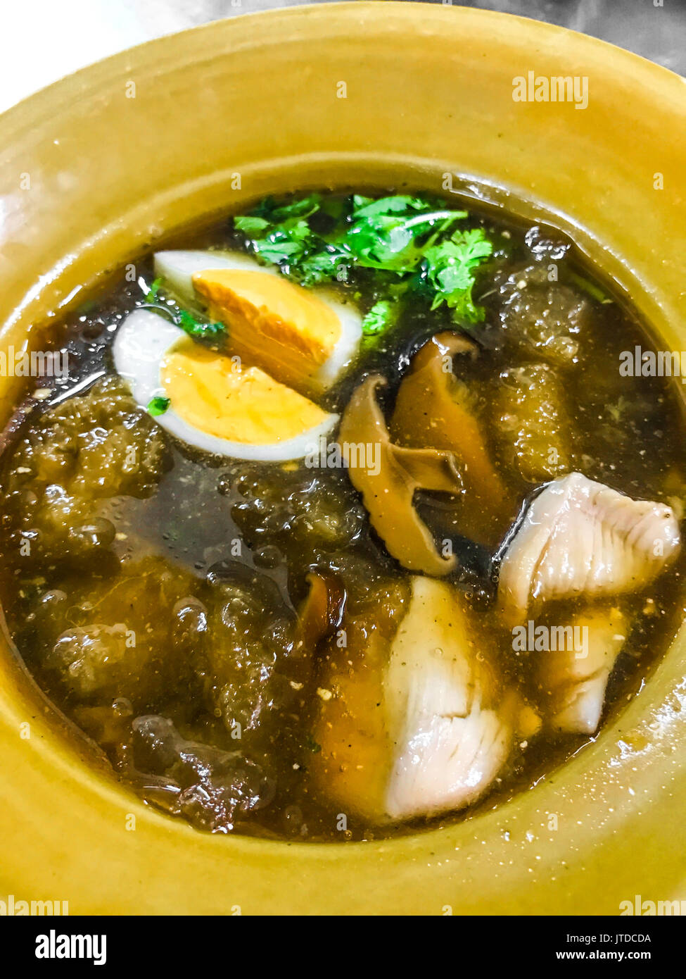 Fish maw soup with meat, egg and vegetable in earthen bowl (Braised