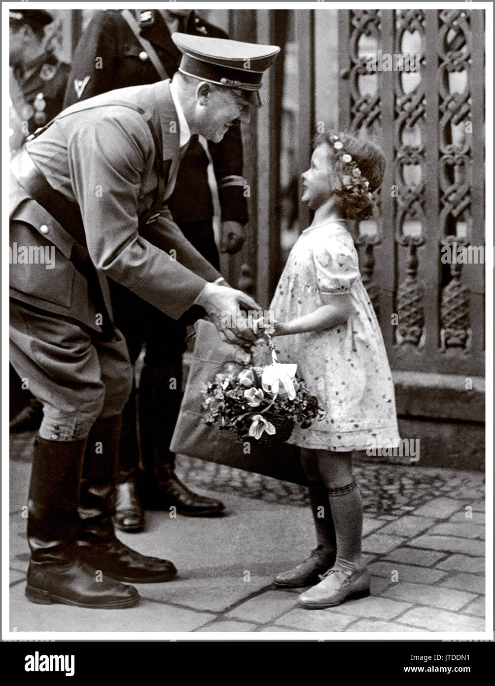 Adolf Hitler and child on a walk being presented with a flower basket by Helga Goebbels 1936. Helga was always said to be Hitler's favorite little girl. (subsequently poisoned by her mother in Hitlers Berlin bunker) Stock Photo