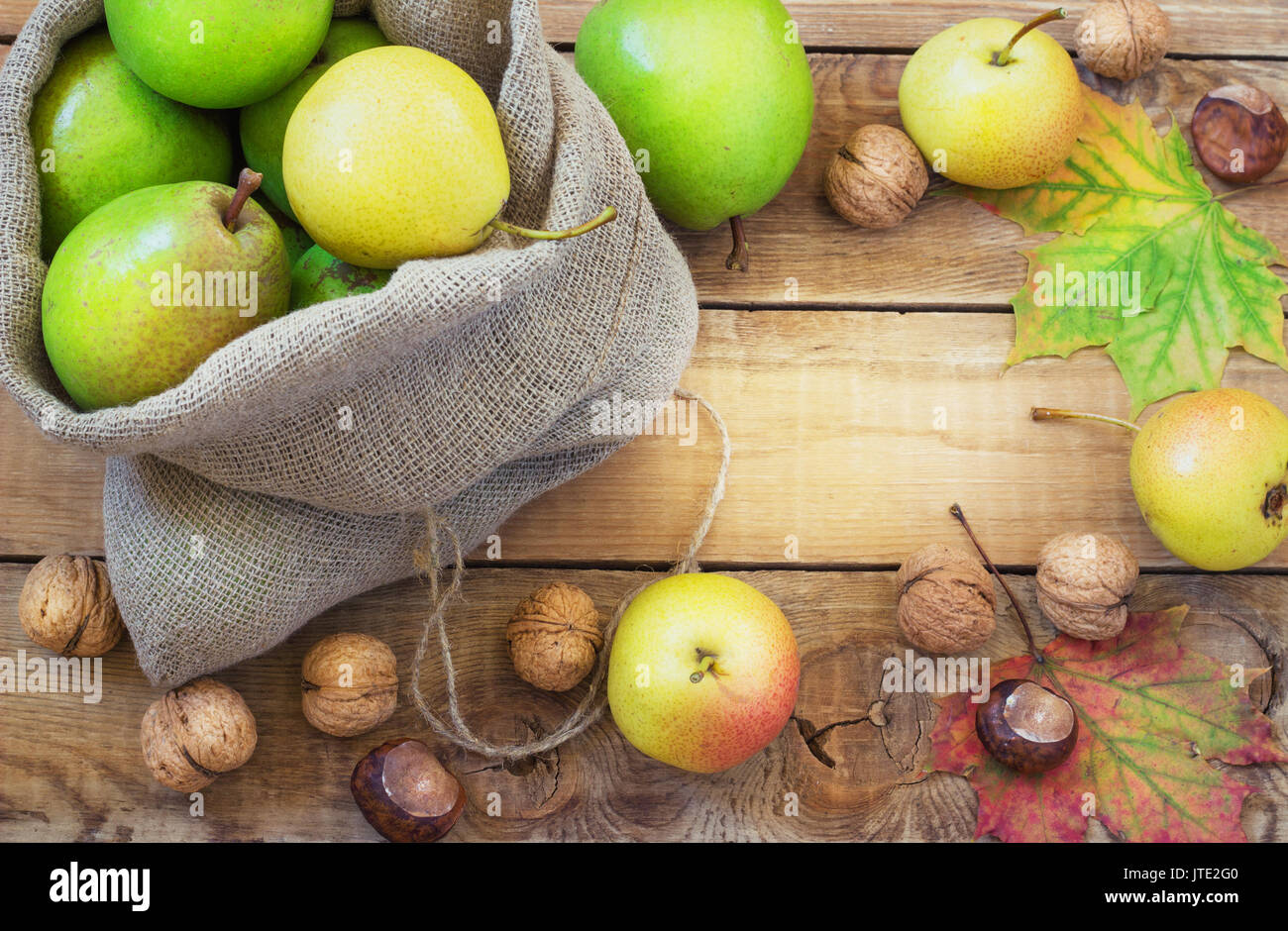 Autumn composition of fruits, nuts and spices - pears, walnuts, maple leaves on a wooden background Stock Photo