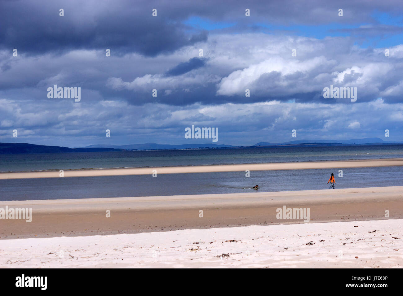 Scotland, Highlands, Nairn Beach, Dramatic Skyline, Person Walking a Dog on the Beach, Golden Sands, Shoreline, Scottish Scenery, Sea, Tide Out Stock Photo