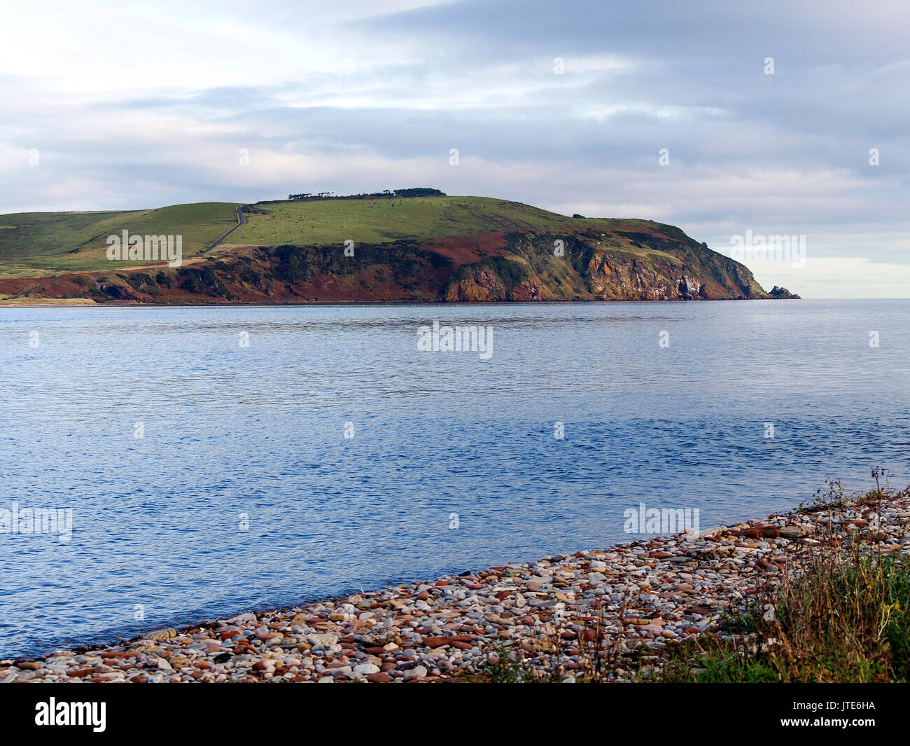 Scotland, Highlands, Sea, Green Mountain Top, Scottish Landscape, Pebbled Beach, Rock Face, Cliff, Nature, Fields, Weeds, Clear Waters, Scenery Stock Photo