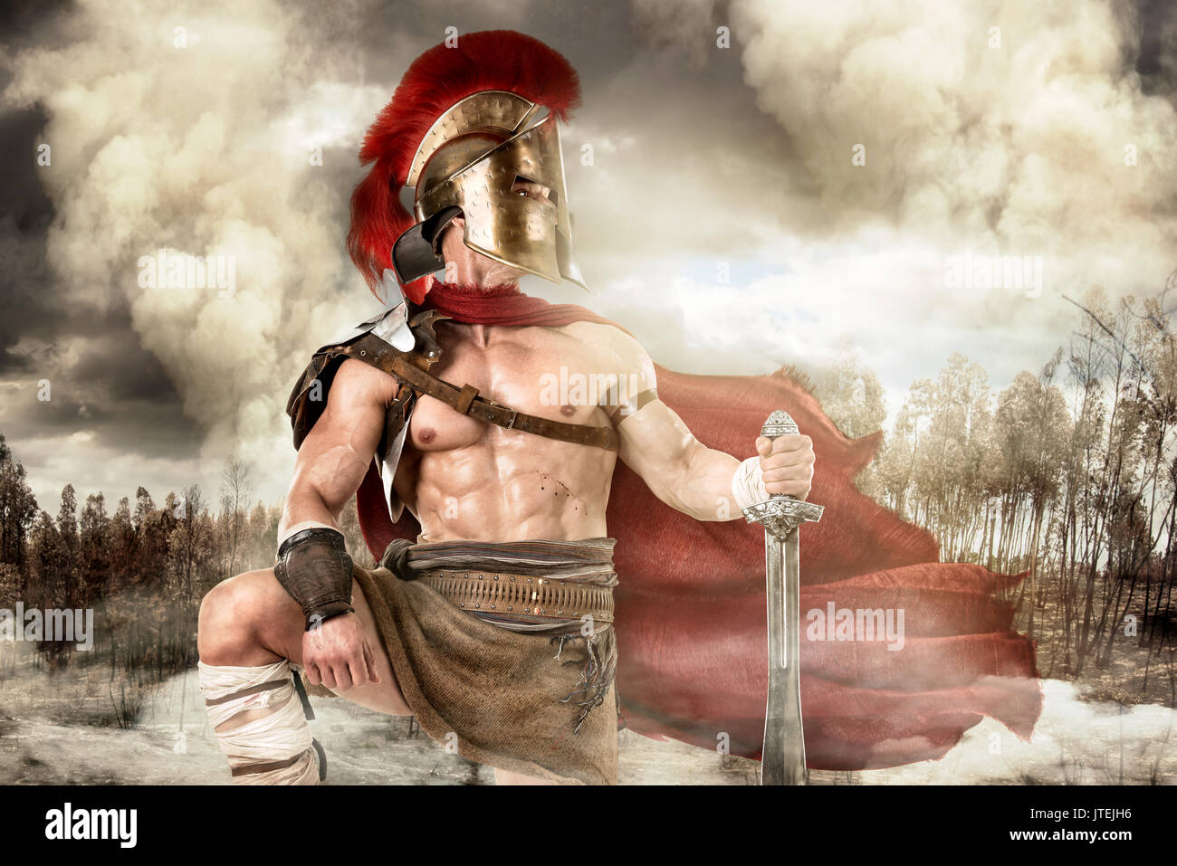 Ancient warrior or Gladiator posing outdoors with helmet Stock Photo