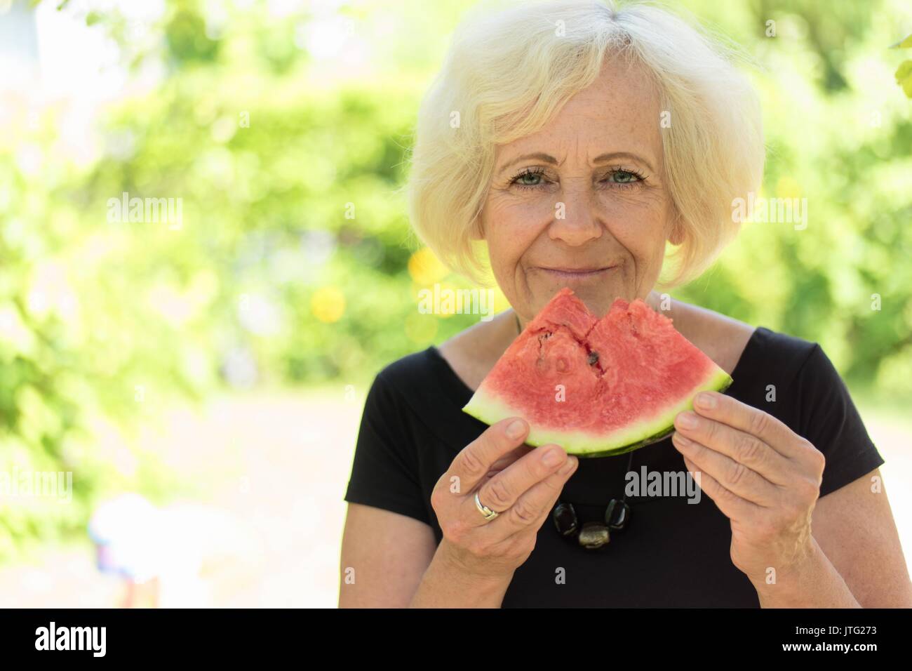 Mature woman eating watermelon. Stock Photo
