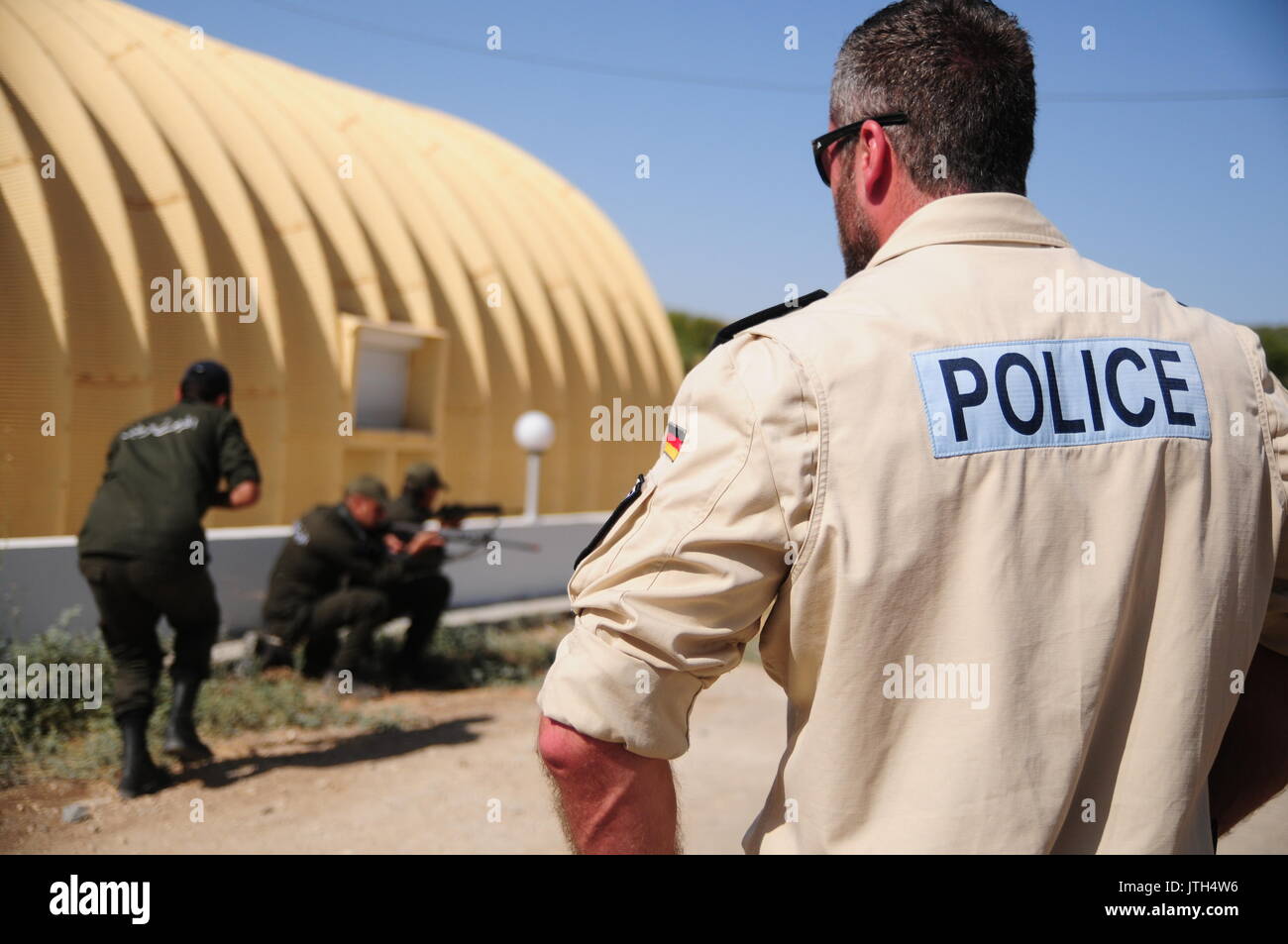 dpatop - Polizeihauptkommissar Steffan August of the German police watches an exercise by the Tunisian national guard at the training centre in Oued Zerga, Tunisia, 2 August 2017. German federal police officers are to train Tunisian border guards. The German police has been in Tunisia since dozens of tourists died in attacks two years ago. Photo: Simon Kremer/dpa Stock Photo