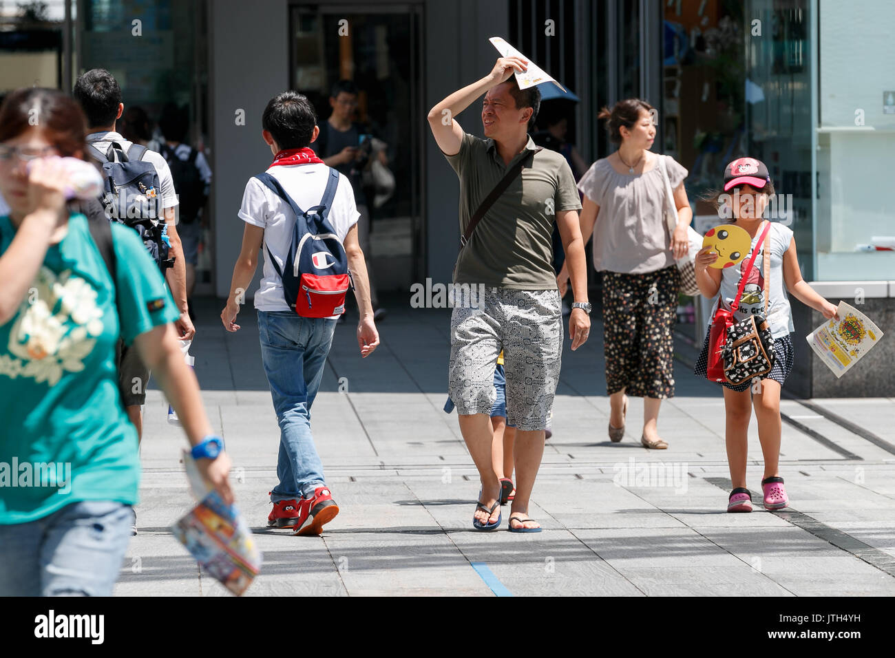 Tokyo, Japan. 6th Aug, 2014. Pedestrians walk under the hot