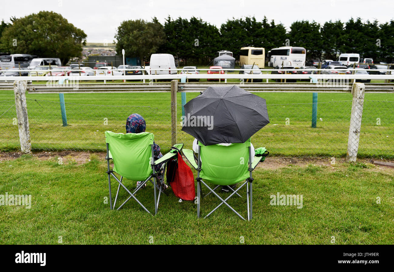 Brighton, UK. 9th Aug, 2017. Racegoers stay dry at the Marstons Race Day in the Maronthonbet Festival of Racing at Brighton Racecourse Credit: Simon Dack/Alamy Live News Stock Photo