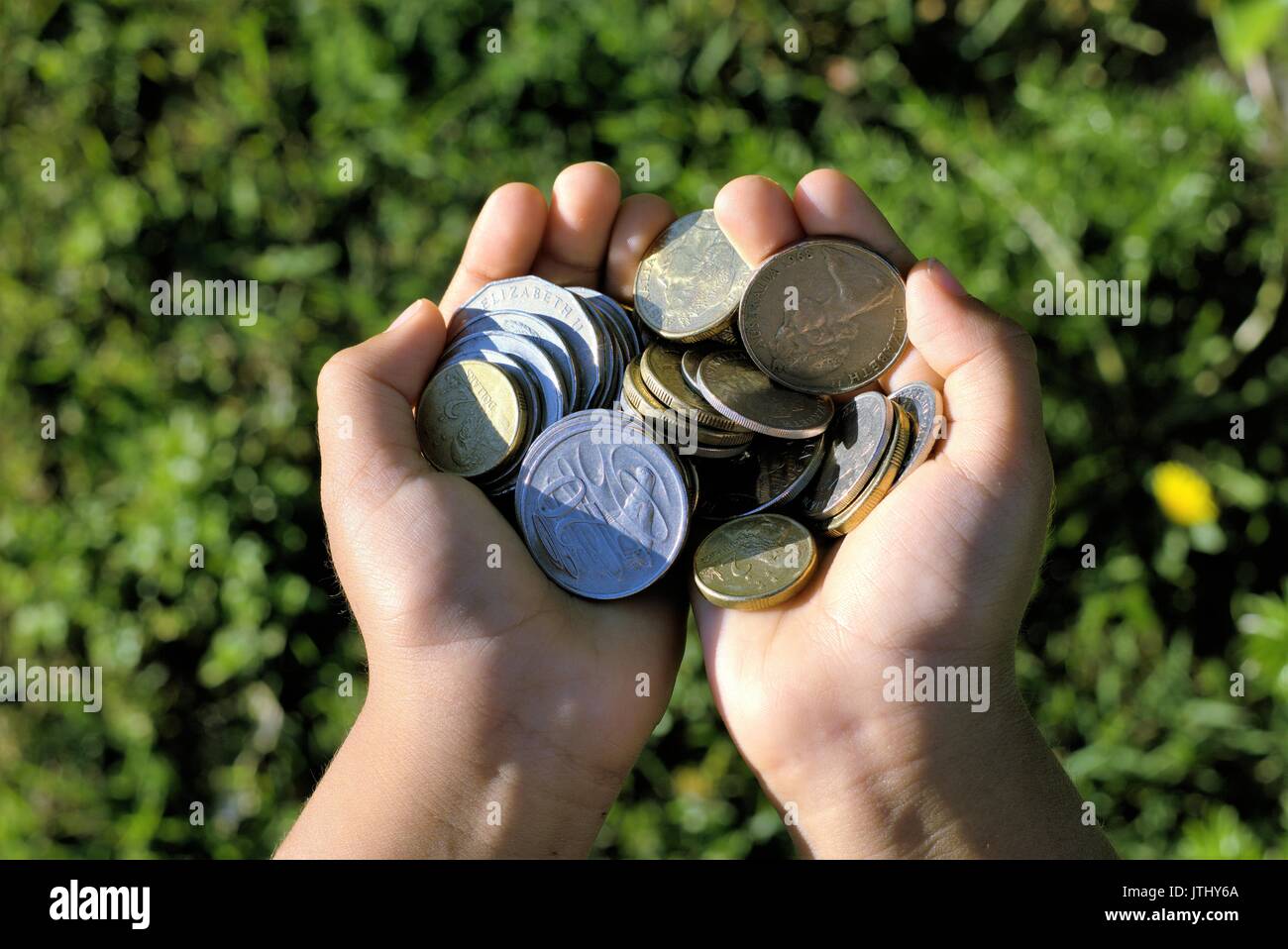 Two hands full of coins. Australian coins in kids hands Stock Photo