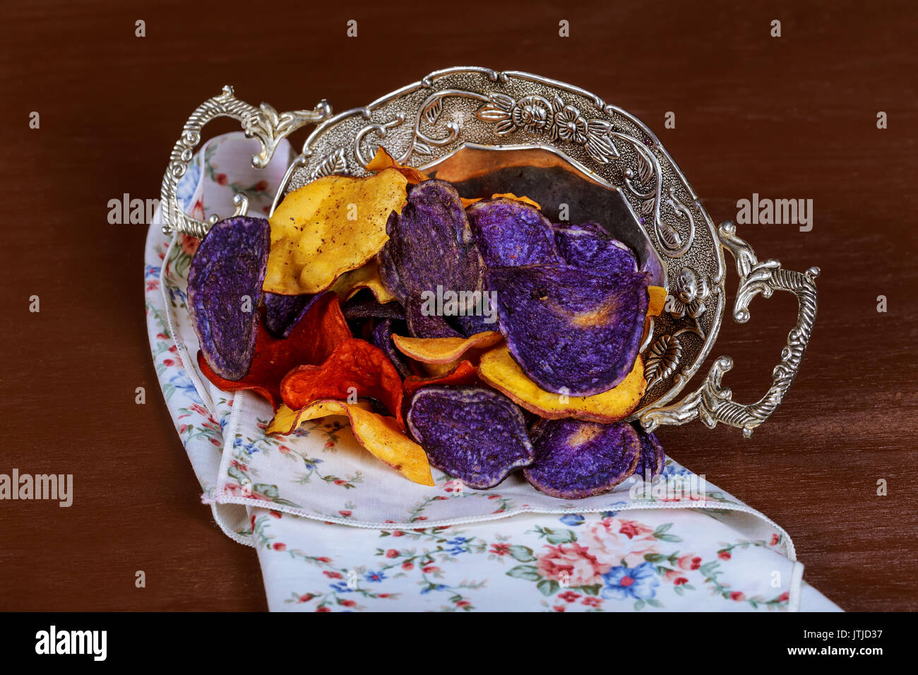 Crunchy appetizer of potato chips made from Crimson red, Purple Majesty and Chipeta, Atlantic potatoes. Potato chips in red, white and blue in a glass Stock Photo