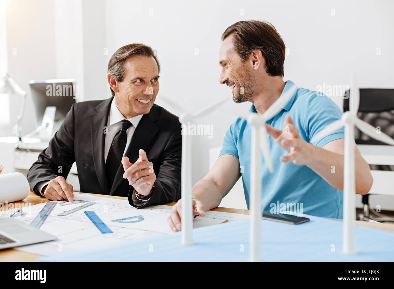 Two engineers working on a wind power station blueprint Stock Photo