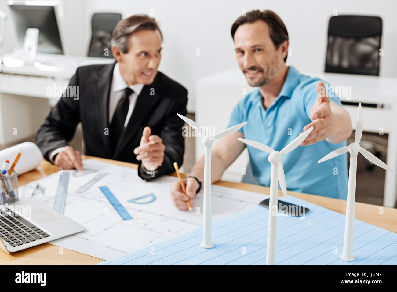 Two engineers pointing at the wind turbine models Stock Photo