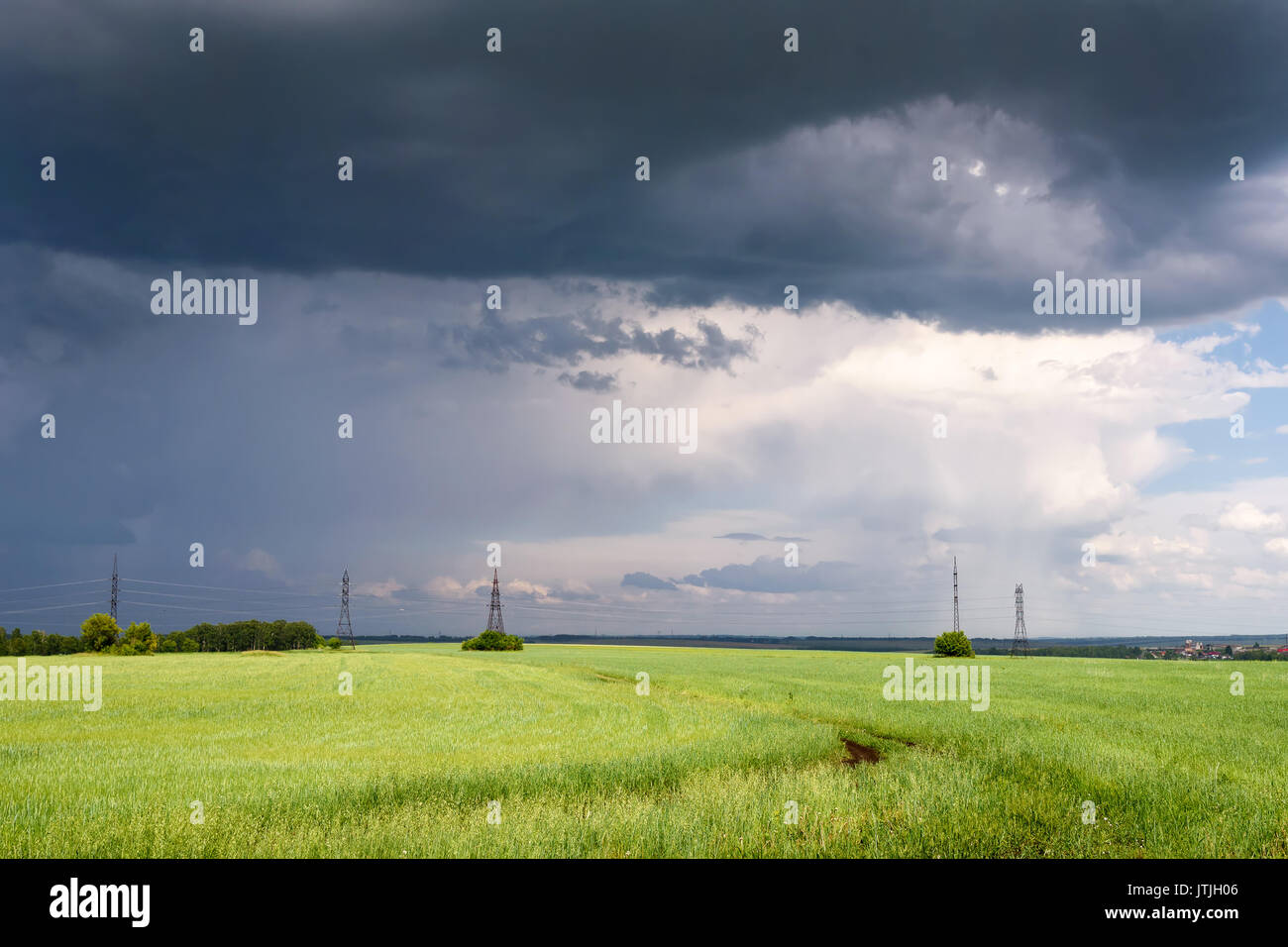 Dramatic Scene: Coming Heavy Thunderstorm over Meadow at Summer Day Stock Photo