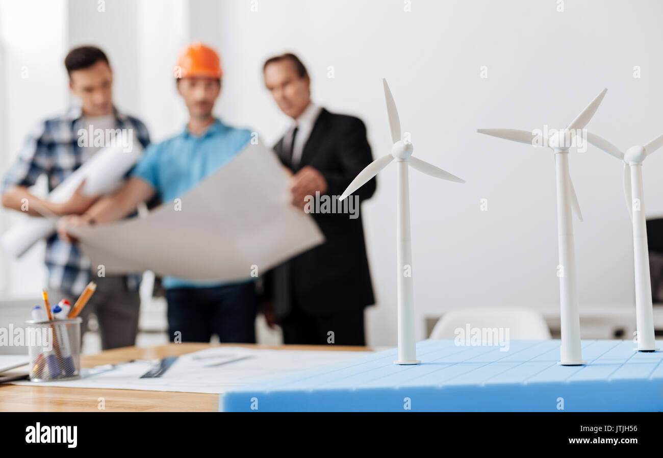 Three men discussing future wind power station project Stock Photo
