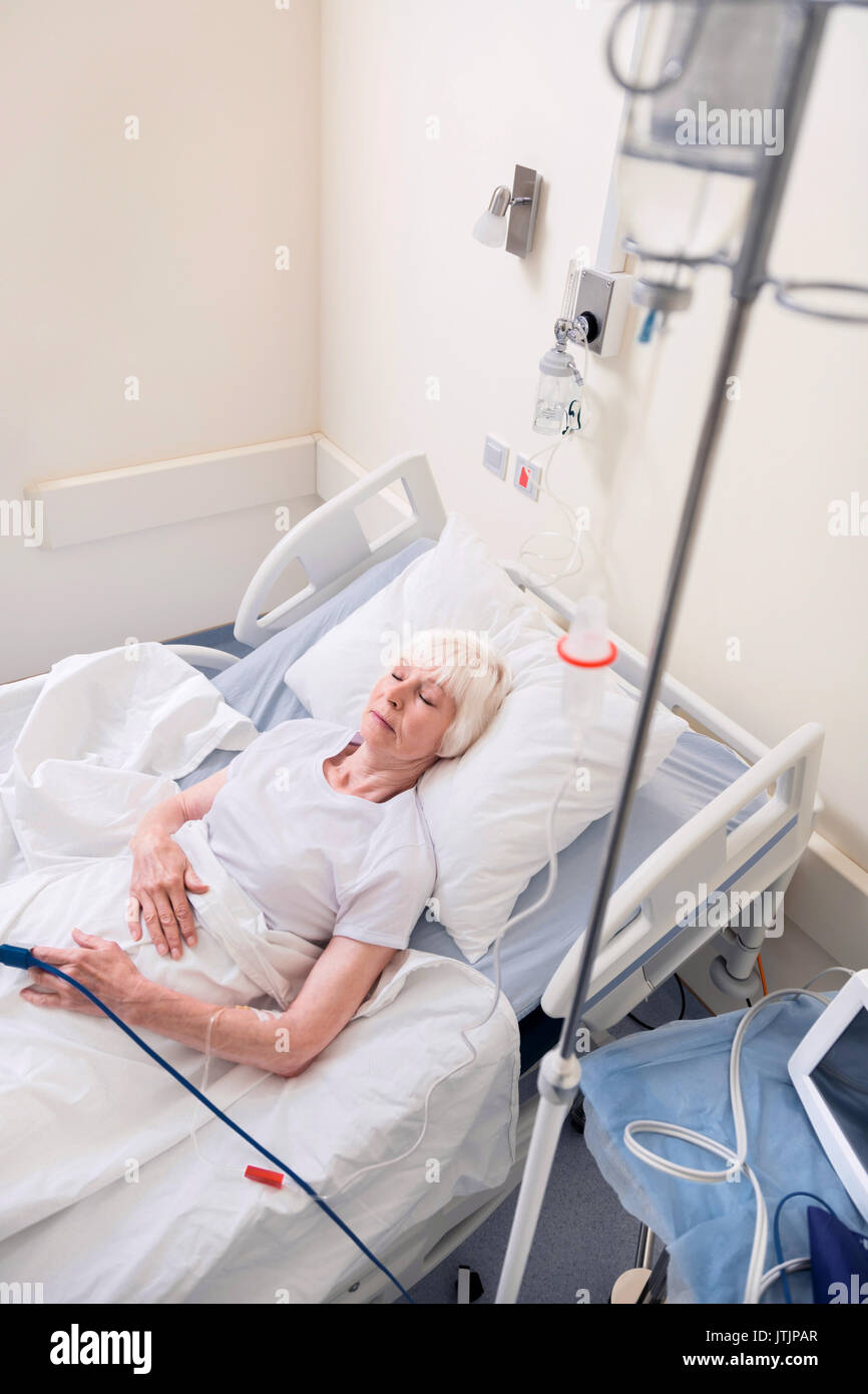 Vulnerable sick woman sleeping in hospital bed Stock Photo