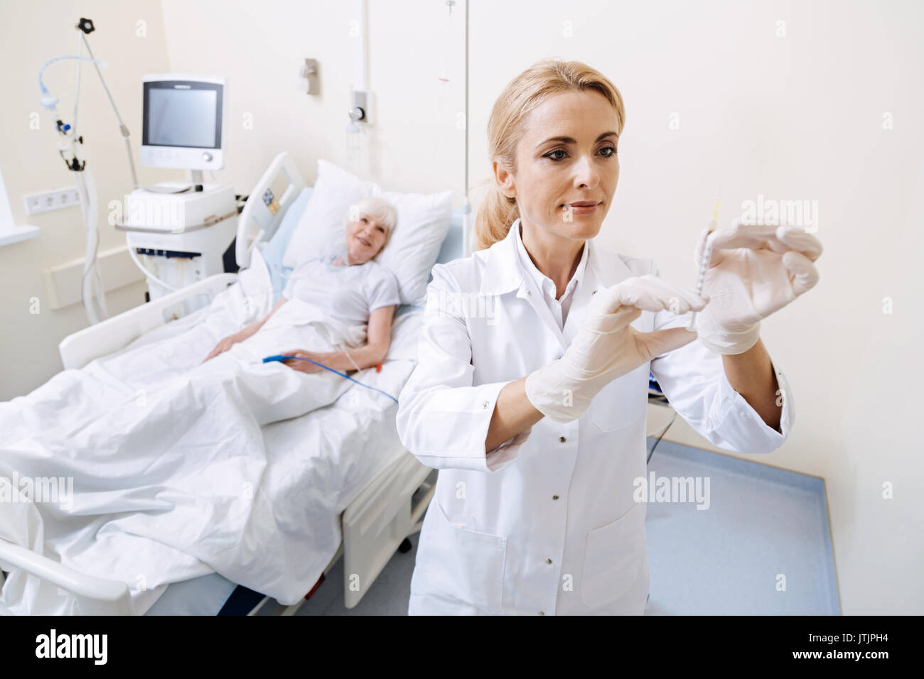 Capable Doctor Scrupulous capable doctor carefully holding a syringe Stock Photo - Alamy