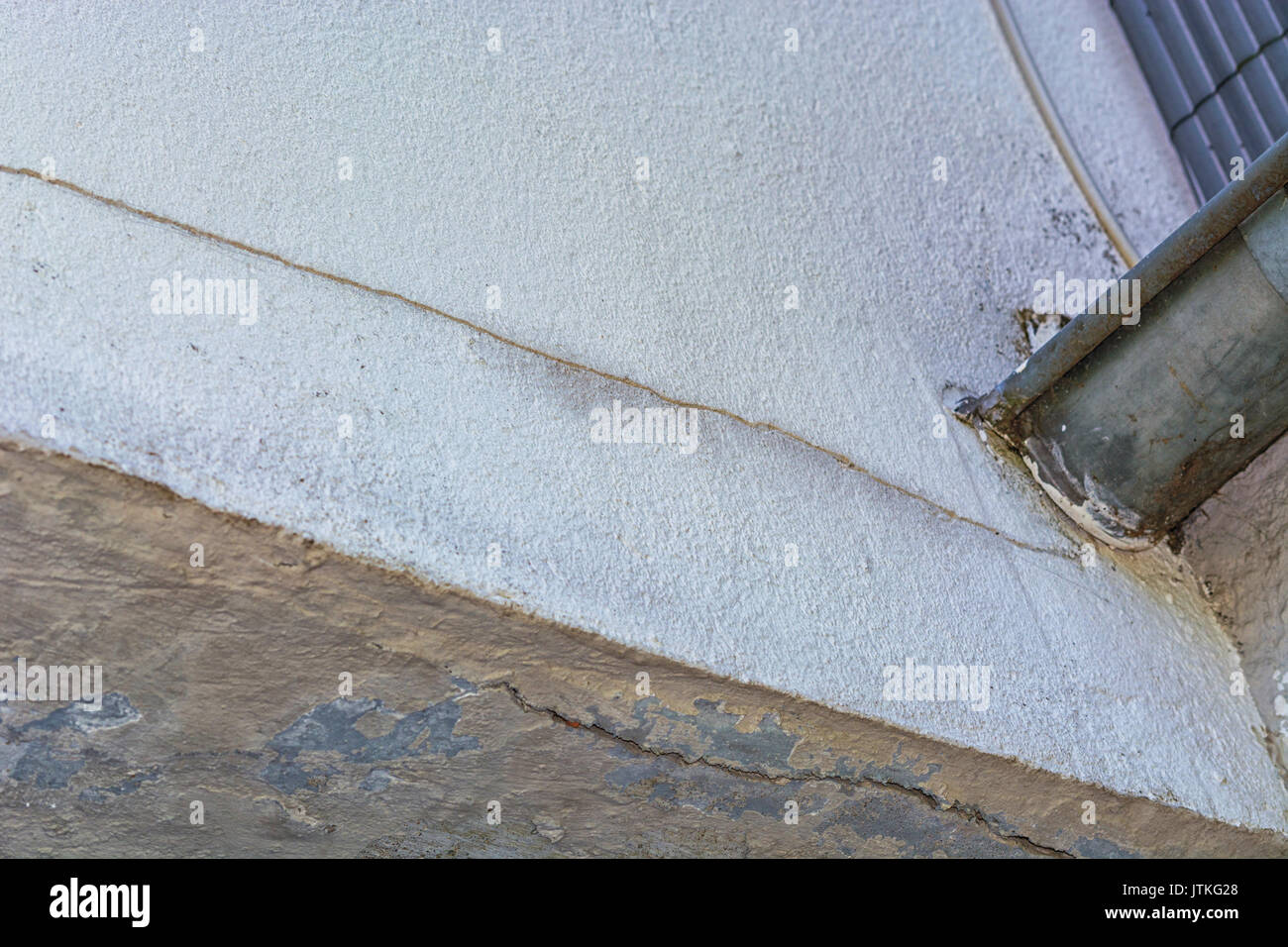 Small cracks in the plaster on the outer wall caused by a tree bend. Stock Photo