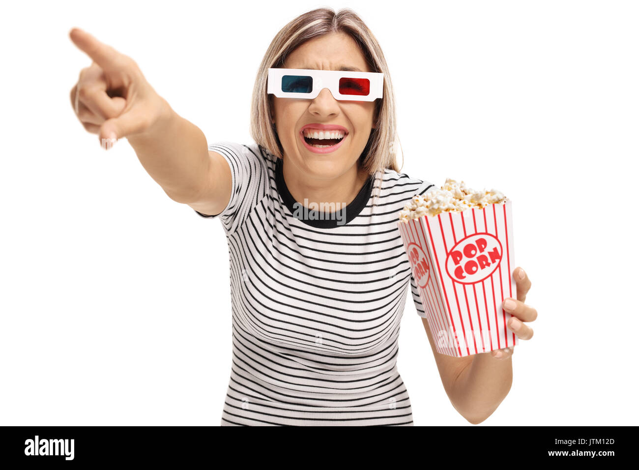 Young woman with 3D glasses and popcorn pointing and laughing isolated on white background Stock Photo
