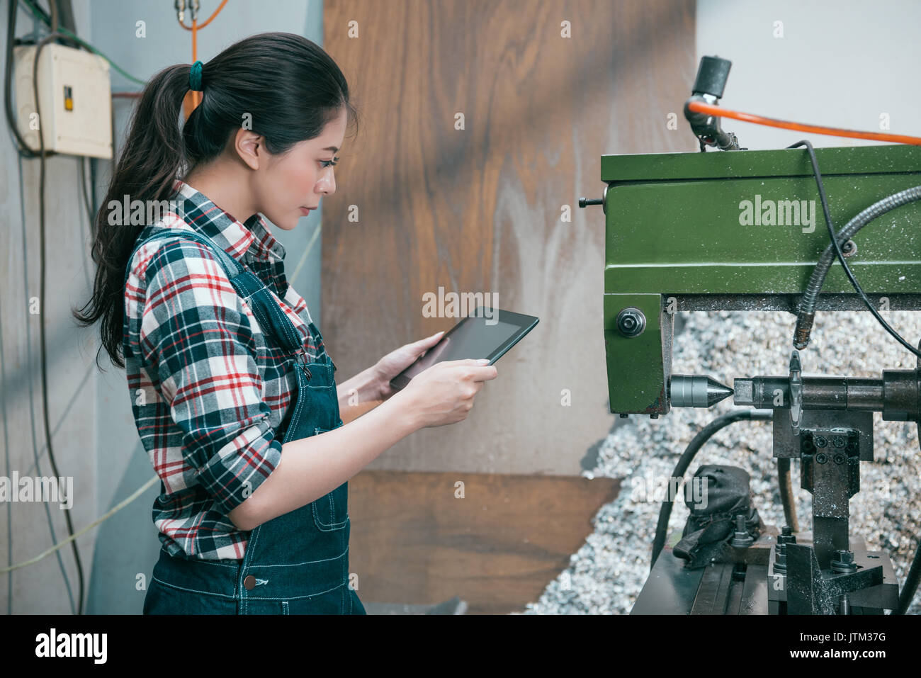beauty elegant milling factory woman worker standing in front of industrial machining using digital tablet computer confirm all online order from clie Stock Photo
