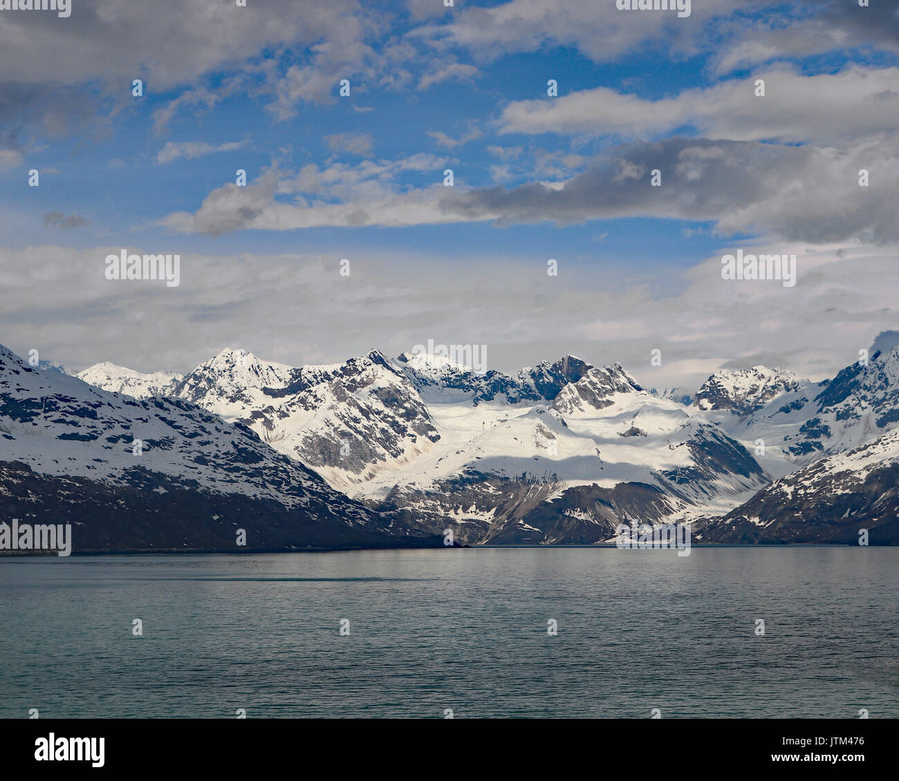 Blue sky and clouds over snow capped mountain range Alaska Stock Photo ...