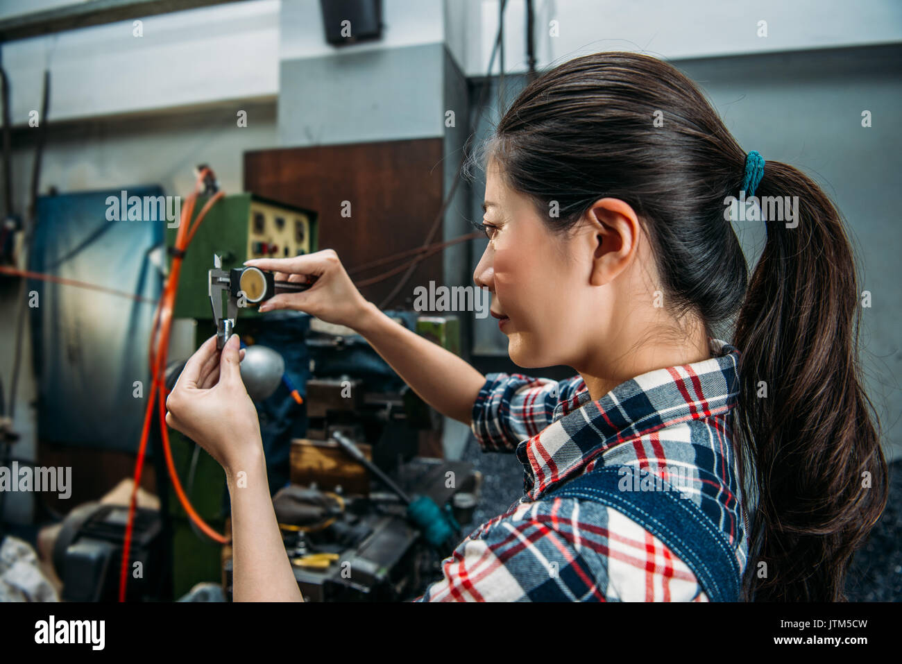 milling machine worker verify manufacturing steel parts accuracy