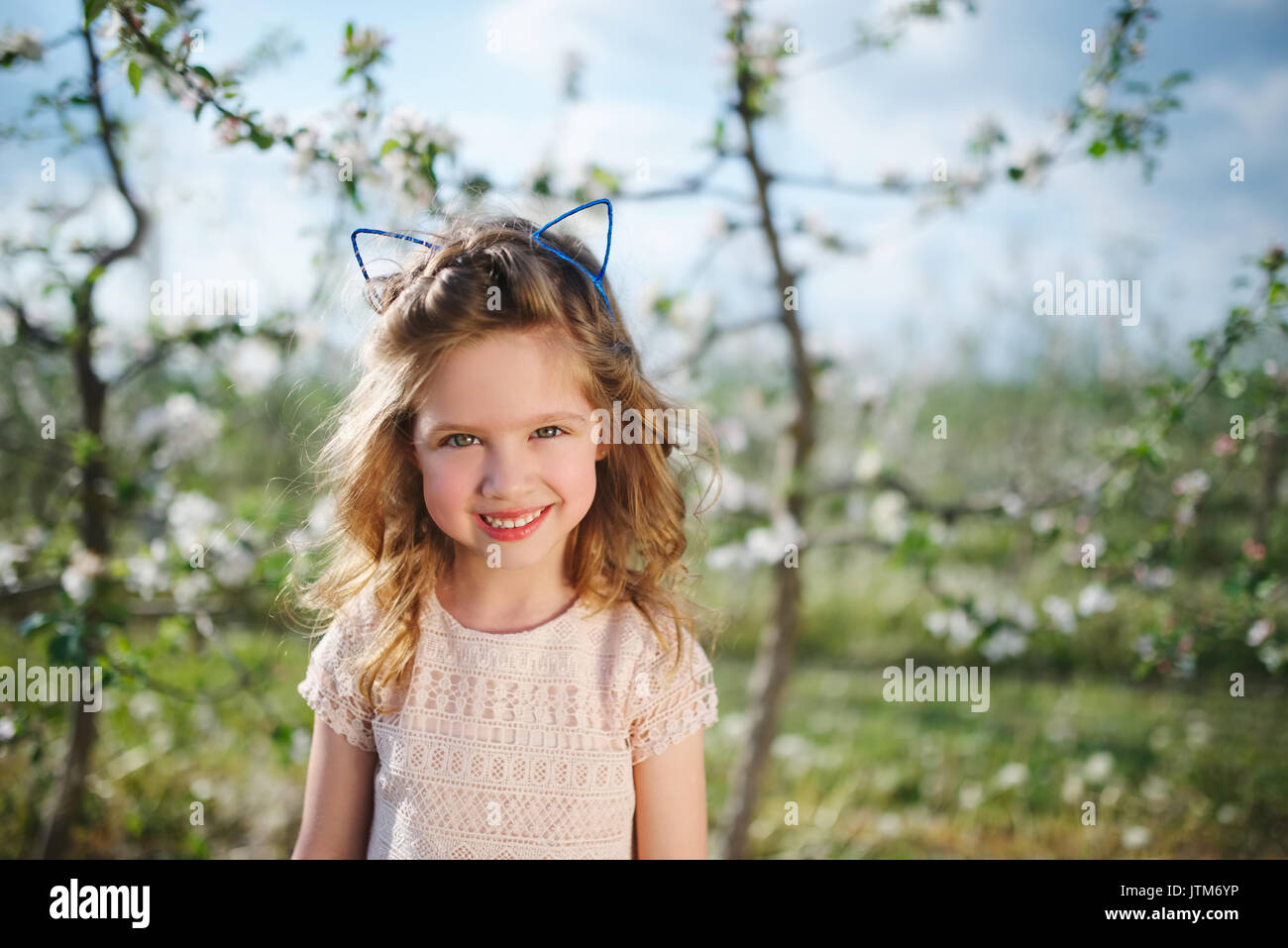 beautiful little girl in blooming garden Stock Photo - Alamy